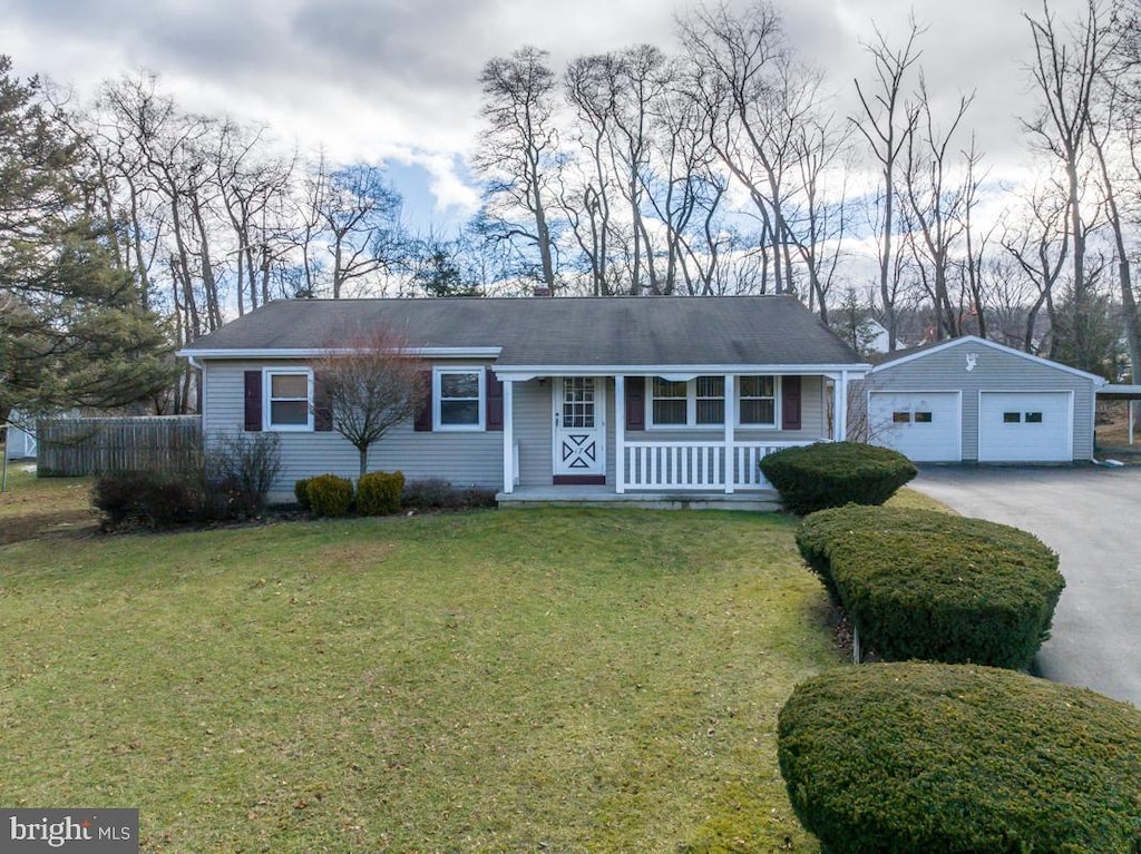 ranch-style house with an outbuilding, a garage, a front lawn, and covered porch