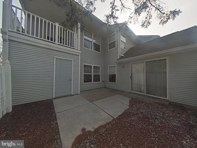 rear view of house with a balcony and a patio