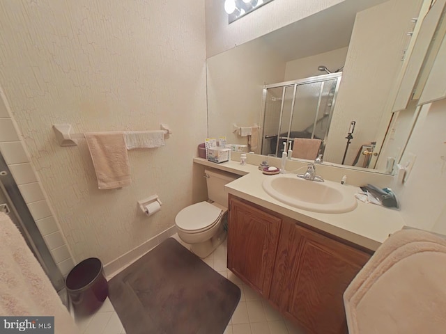 bathroom with vanity, toilet, tile patterned floors, and a shower with shower door