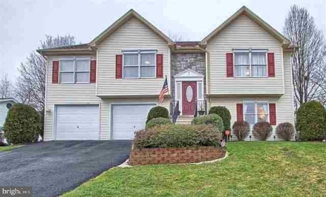 bi-level home with a garage and a front lawn