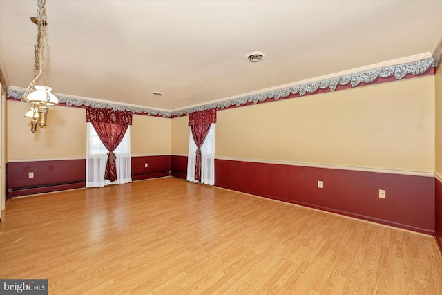 spare room with wood-type flooring, ornamental molding, and baseboard heating