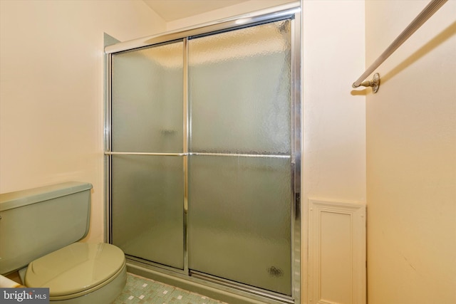 bathroom featuring toilet and an enclosed shower