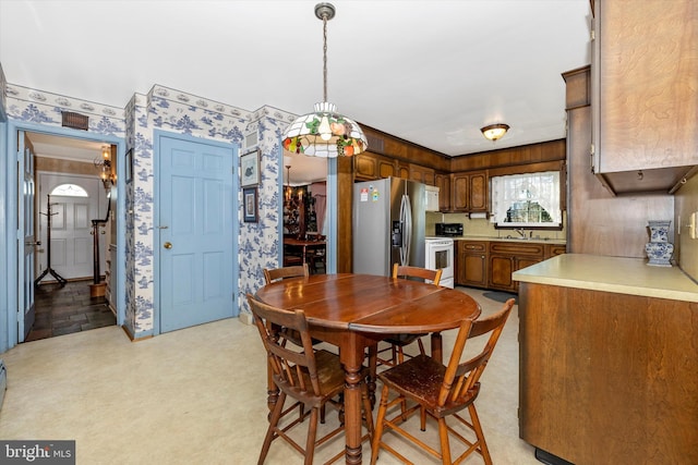 dining room featuring sink and light carpet