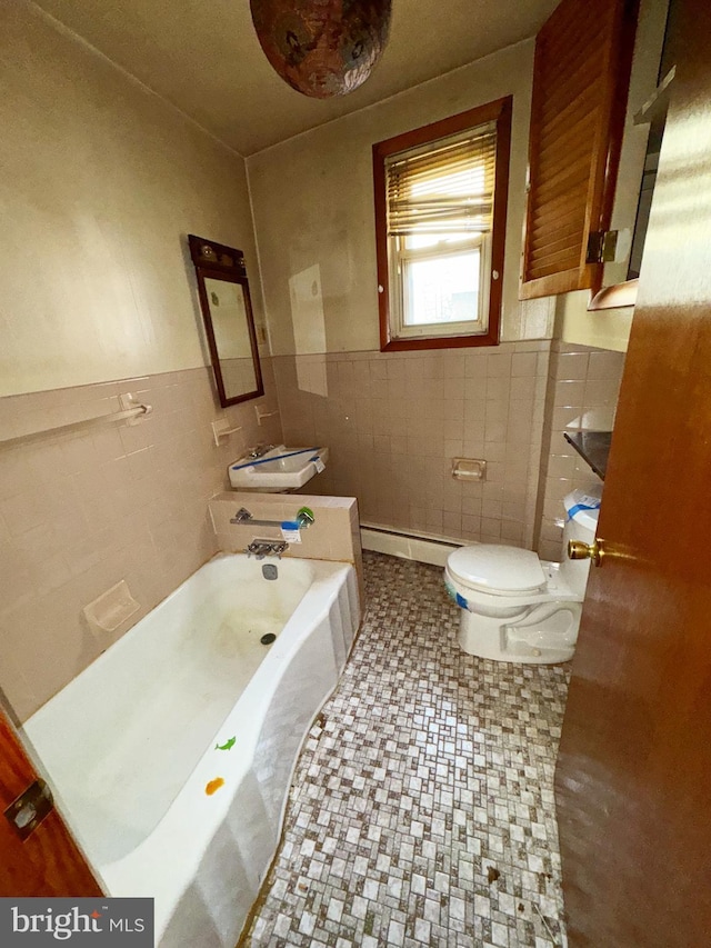 bathroom featuring sink, baseboard heating, tile walls, a bathing tub, and toilet