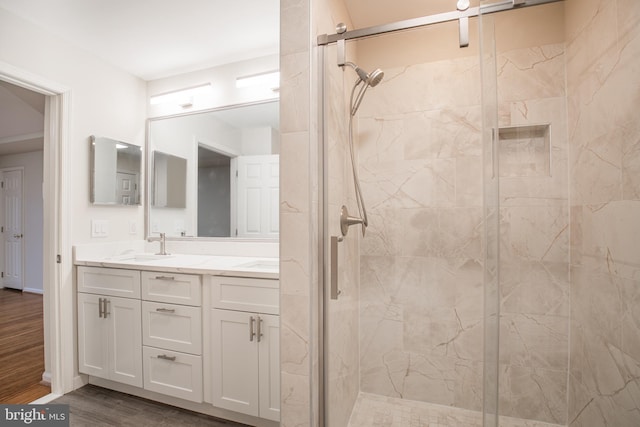 bathroom featuring hardwood / wood-style flooring, vanity, and a shower with shower door