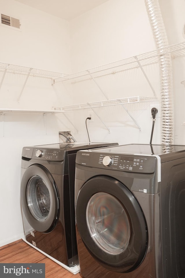 laundry room featuring hardwood / wood-style floors and washer and dryer