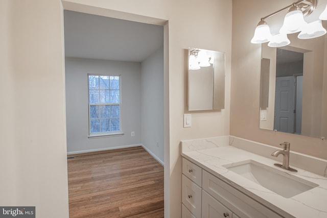 bathroom featuring vanity, hardwood / wood-style flooring, and an inviting chandelier