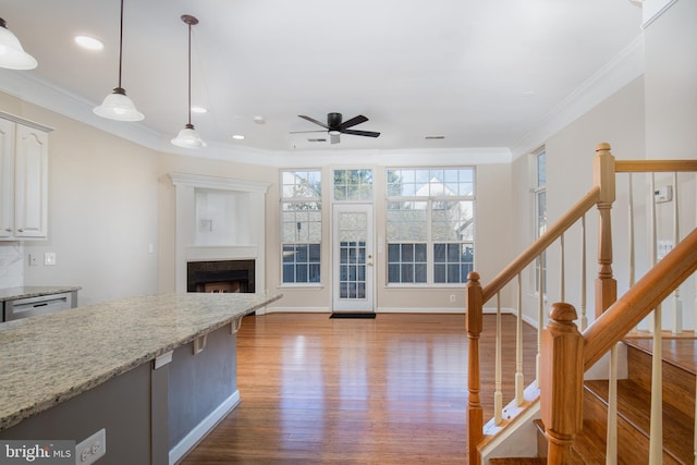 kitchen featuring ornamental molding, white cabinets, and light stone counters