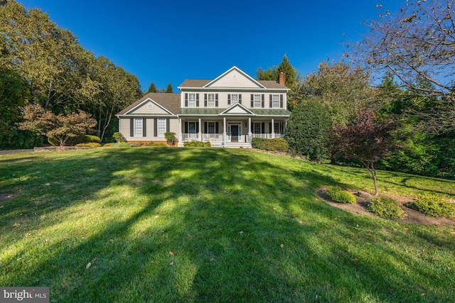 greek revival inspired property with a front yard and covered porch