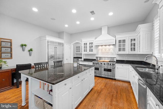 kitchen with custom exhaust hood, high end appliances, and white cabinets