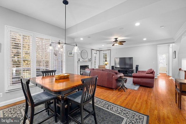 dining area with hardwood / wood-style flooring, ornamental molding, and ceiling fan