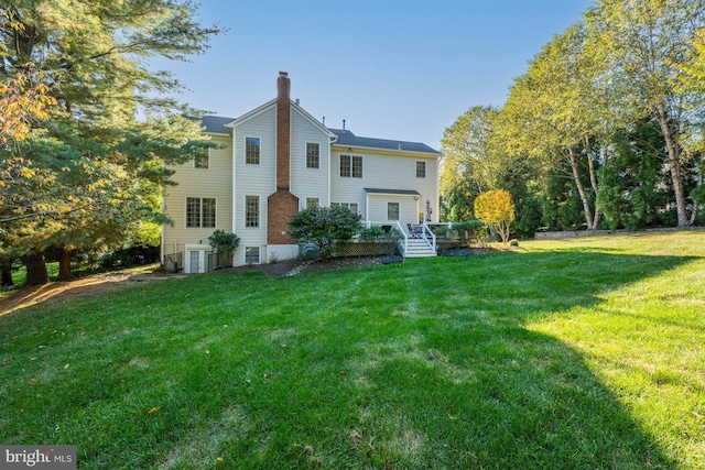 back of property with a wooden deck and a lawn