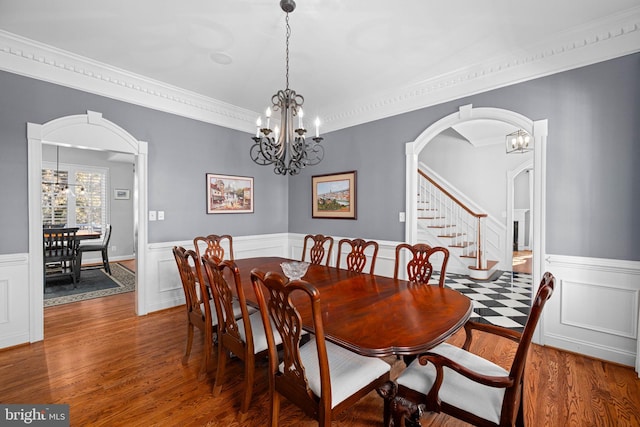 dining area with an inviting chandelier, hardwood / wood-style floors, and crown molding