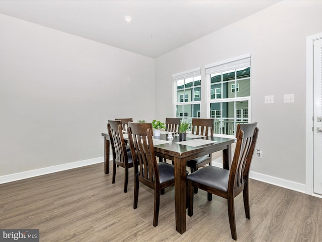 dining space with wood-type flooring