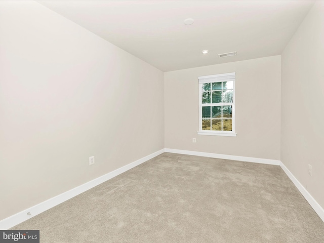 spare room featuring light colored carpet