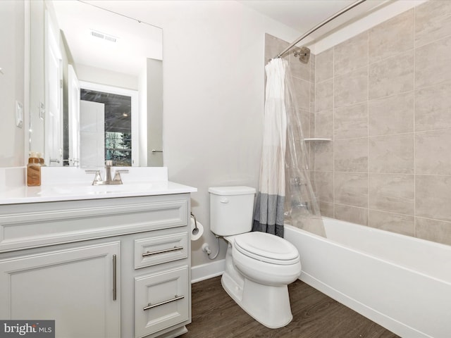 full bathroom featuring hardwood / wood-style flooring, vanity, shower / tub combo, and toilet