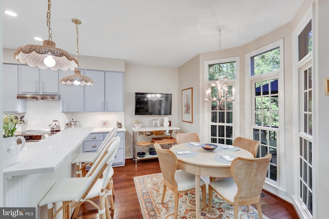 dining space featuring an inviting chandelier and dark hardwood / wood-style floors