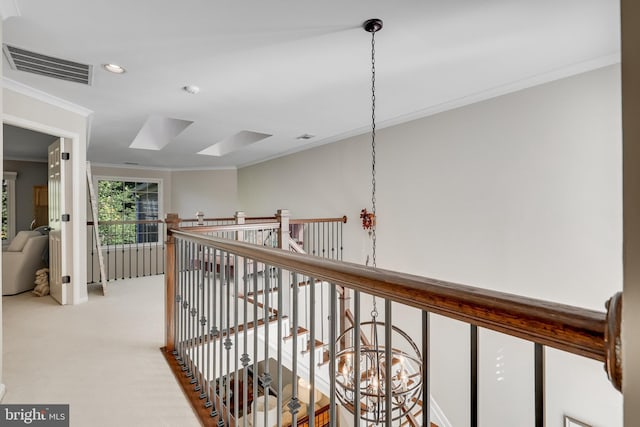 hallway featuring crown molding, a skylight, and light colored carpet