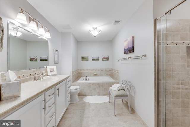 bathroom with vanity, tile patterned flooring, tiled bath, and toilet