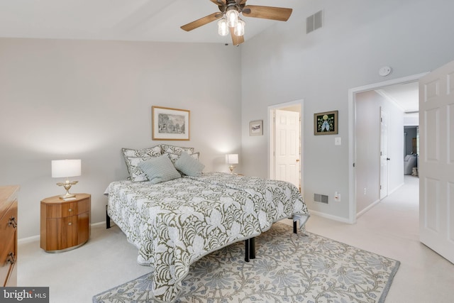 bedroom featuring a towering ceiling, light colored carpet, and ceiling fan