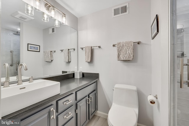 bathroom featuring vanity, hardwood / wood-style floors, toilet, and walk in shower