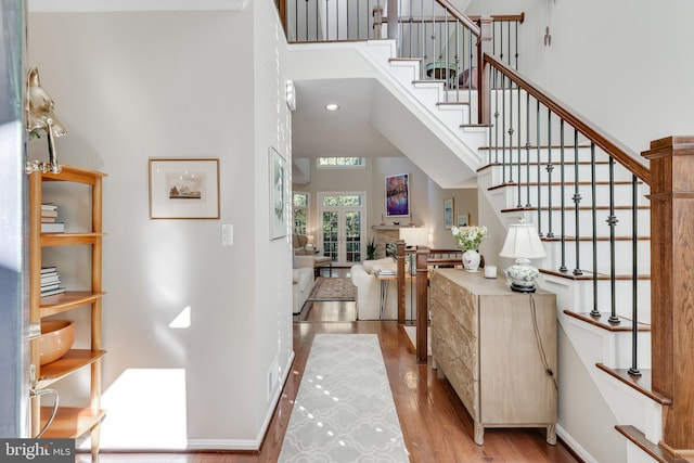 entrance foyer featuring a towering ceiling and light hardwood / wood-style flooring