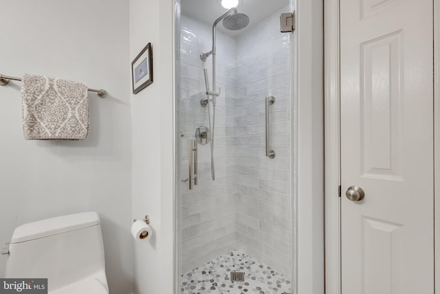 bathroom with toilet and a shower with shower door