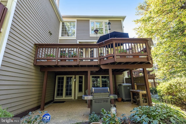 rear view of property with a wooden deck, central AC, and a patio area