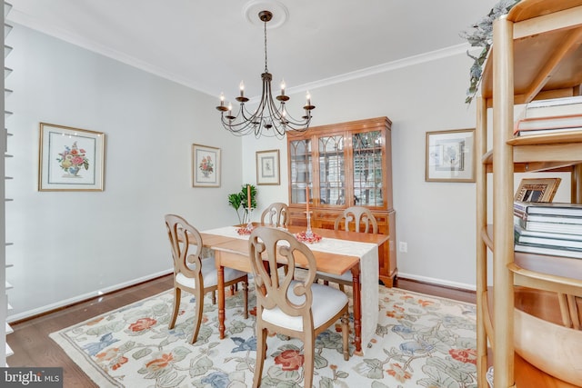 dining area with a notable chandelier, crown molding, and wood-type flooring