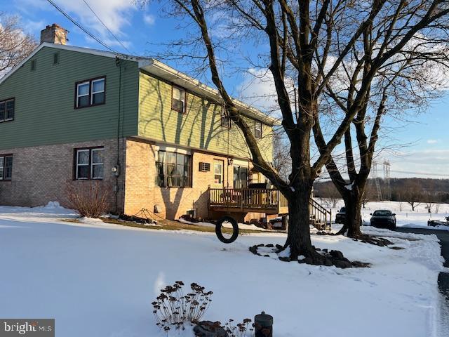 view of snowy exterior with a deck