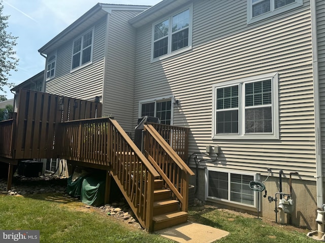 rear view of house featuring central AC unit and a deck