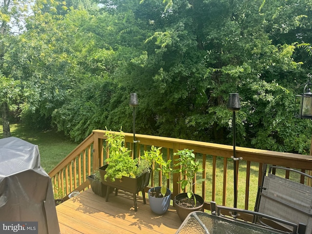 deck featuring area for grilling and a lawn