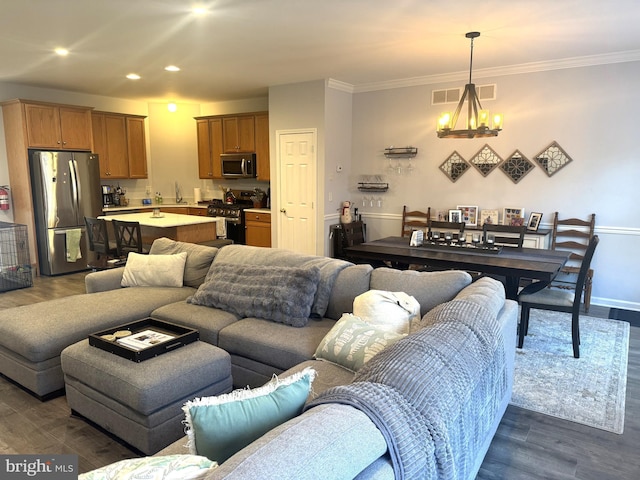 living room featuring a notable chandelier, crown molding, and dark hardwood / wood-style floors