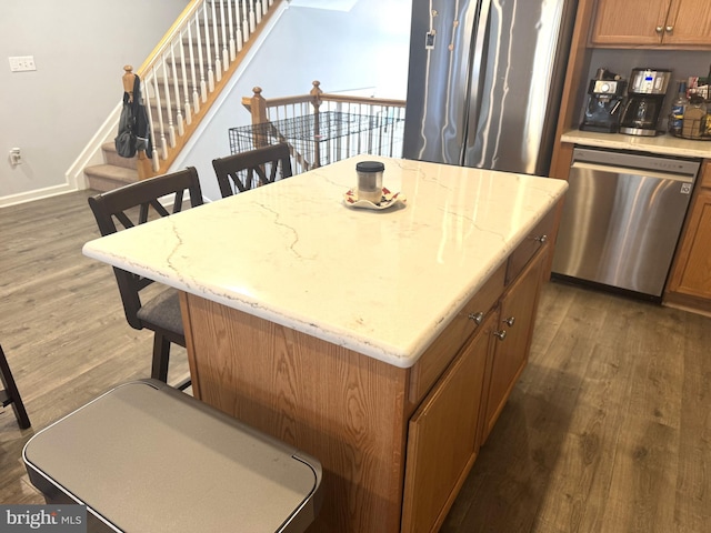 kitchen featuring a kitchen island, dark wood-type flooring, and stainless steel dishwasher