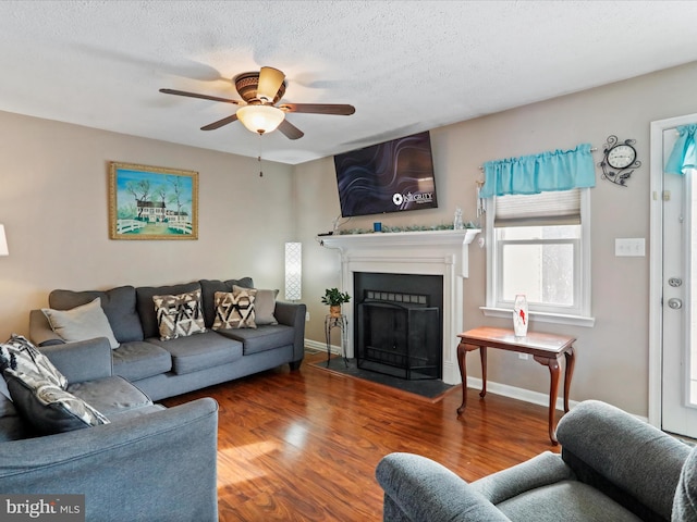 living room with wood-type flooring, a textured ceiling, and ceiling fan