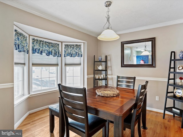 dining room featuring crown molding and light hardwood / wood-style floors