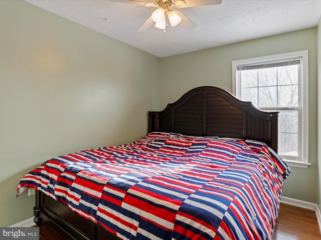 bedroom featuring ceiling fan, hardwood / wood-style floors, and a textured ceiling