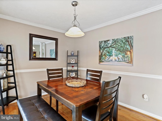 dining space featuring crown molding and hardwood / wood-style flooring