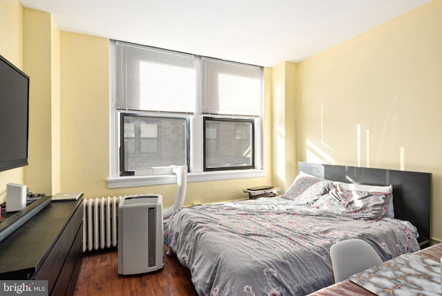 bedroom featuring dark hardwood / wood-style flooring and radiator