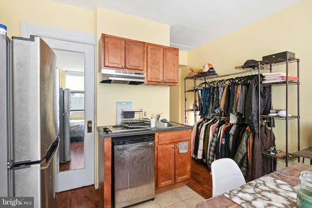 kitchen featuring stainless steel refrigerator, dishwashing machine, and light tile patterned flooring