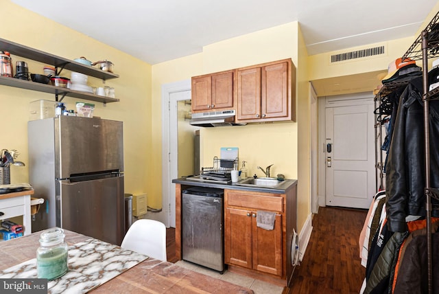 kitchen featuring stainless steel refrigerator, dark wood-type flooring, dishwasher, and sink