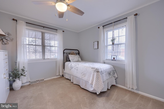 bedroom with crown molding, light colored carpet, and ceiling fan