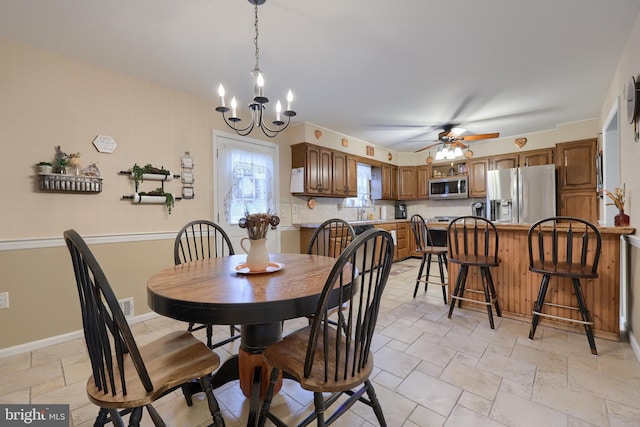 dining space featuring ceiling fan with notable chandelier