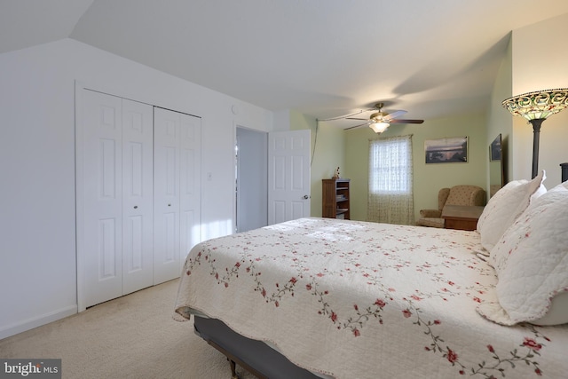 carpeted bedroom with ceiling fan, vaulted ceiling, and a closet