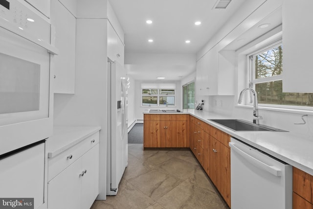 kitchen featuring white cabinetry, white appliances, and sink