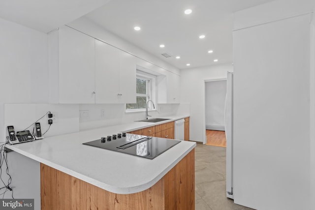 kitchen with white cabinetry, sink, black electric stovetop, white dishwasher, and kitchen peninsula