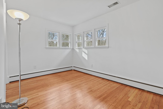 unfurnished room featuring light hardwood / wood-style floors and baseboard heating