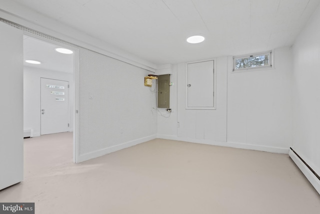 basement with a baseboard radiator and electric panel