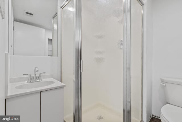 bathroom featuring walk in shower, vanity, and toilet