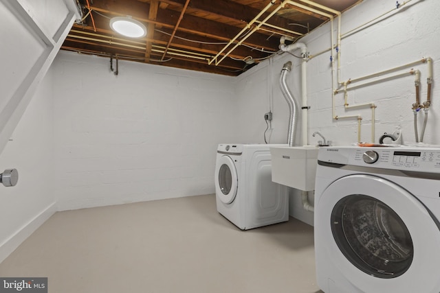 clothes washing area featuring sink and washer and dryer